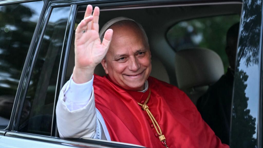 Pope Leo XIV waving goodbye from a moving vehicle during his departure from Africa