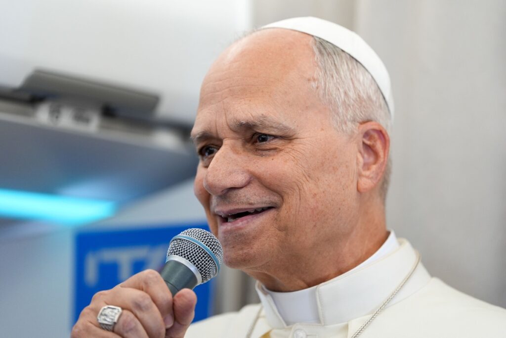 Pope speaking into a microphone during an in-flight press conference after his visit to Africa