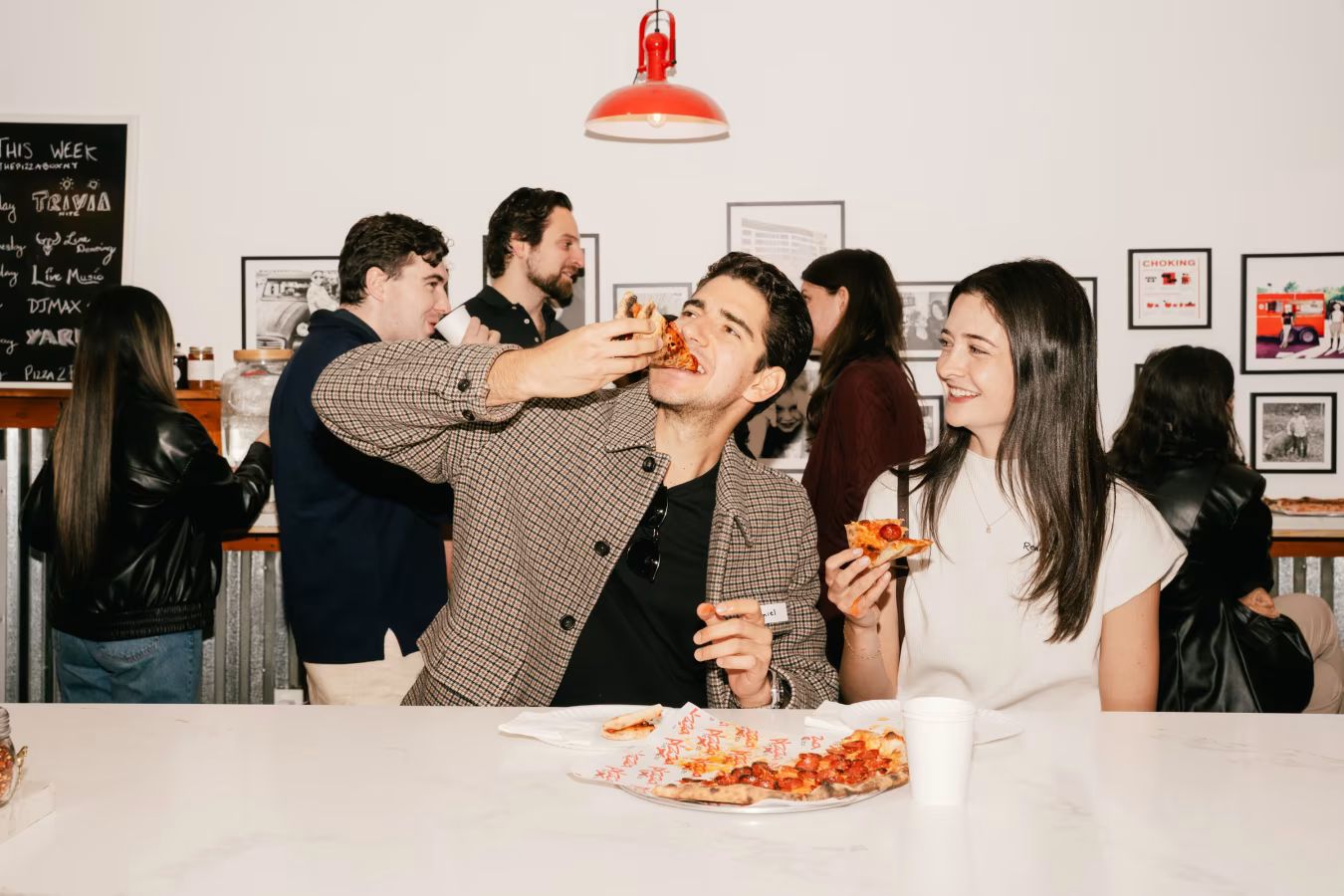Group of young Catholics gathered for a “Pizza to Pews” faith event featuring pizza, fellowship, and church participation.